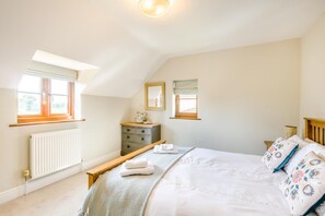 A bedroom with a bed, a dresser, a radiator, and two windows. - 4 Bed in Melton Constable (oc-77924) (Briston)