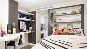 Una camera da letto moderna con un letto, una scrivania e una libreria.