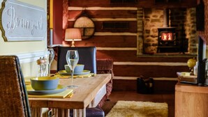 A cozy dining area with a wooden table set for two, a stone fireplace, and a 'Be our guest' sign on the wall. - 1 Bed in Crook (oc-78487) (North Bitchburn)
