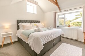 A bedroom with a bed, bedside table, and a window with a view. - 1 Bed in Penzance (oc-78517) (Newlyn)