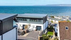 Un bâtiment moderne doté d’un toit plat, de grandes fenêtres et d’un espace de stationnement.