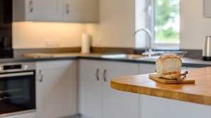 Ovn, oppvaskmaskin, høy barnestol og kjøkkenutstyr
