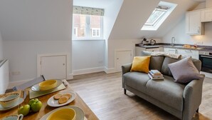 Ein modernes Loft mit Essbereich, einer Couch, einer Küche und einem Oberlicht.