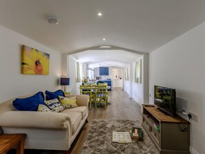 A modern living room with a sofa, a television, and a game board.
