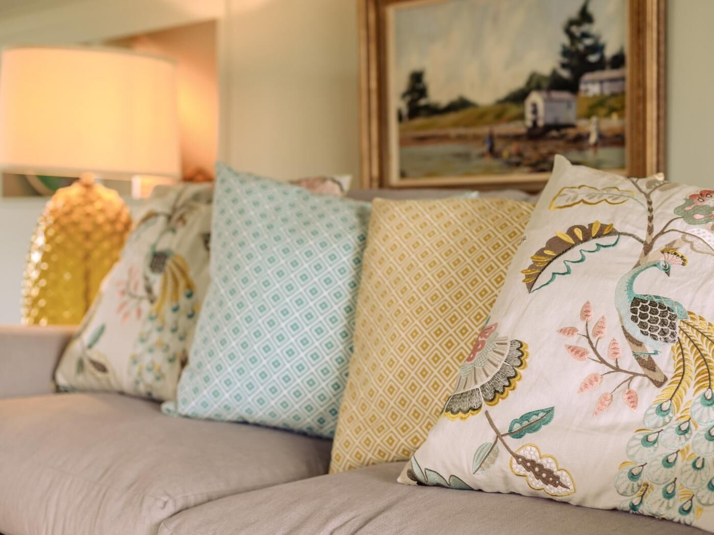 A sofa with decorative pillows featuring embroidered designs.