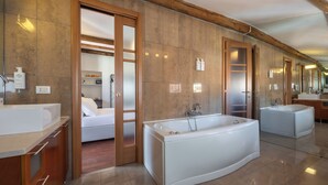 Une salle de bain spacieuse avec deux grandes baignoires, des portes en bois et un meuble-lavabo avec un miroir.