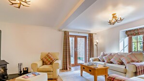 A cozy living room with a fireplace, a sofa, a chair, and a coffee table. - 2 Bed in Driffield (oc-79280) (Wold Newton)