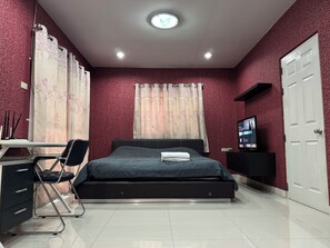 A bedroom with a bed, a desk with a chair, a television, and a door. - Simple and Private Living Home near Suvarnabhumi Airport 23 min (บางโฉลง)