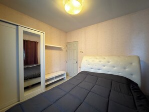 A bedroom with a bed, a wardrobe, a door, and a light fixture. - Simple and Private Living Home near Suvarnabhumi Airport 23 min (บางโฉลง)