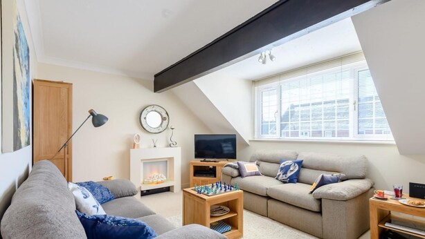 A modern living room with a fireplace, two sofas, a TV, and a chessboard. - 1 Bed in Lymington (oc-79332) (Milford on Sea)