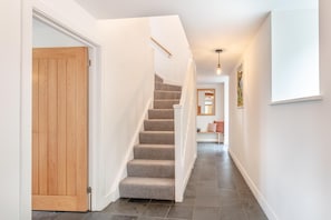 A staircase leading to a landing with a wooden door on the left.