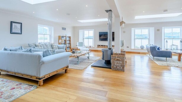 A spacious living room with a sofa, coffee table, and a fireplace. - 4 Bed in Dunoon (oc-79529) (Ardentinny)