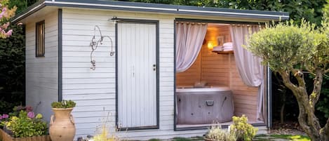 A small, single-story structure with a door leading to a room containing a massage chair.