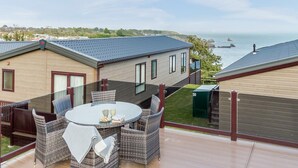A modern house with a patio, a round table, and chairs. - 2 Bed in Brixham (oc-79989) (Brixham)
