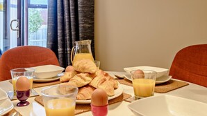 Ett frukostbord med croissanter, ägg och apelsinjuice.