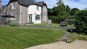 A two-story stone building with a white facade, a paved driveway, and a well-maintained lawn. - 3 Bed in Chepstow (oc-81047) (Shirenewton)