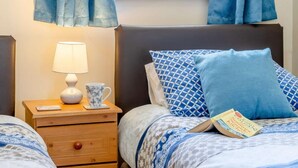 Ein Schlafzimmer mit Bett, Nachttisch, Lampe und einer Tasse.