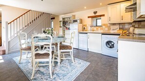 Eine moderne Küche mit Essbereich, Treppe und Waschmaschine.
