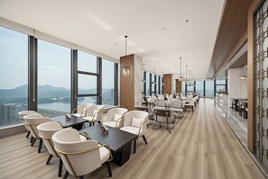A modern conference room with large windows, a long table, and several chairs. - LANDISON PLAZA HOTEL (Lishui)