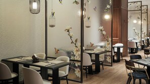 A restaurant interior with tables, chairs, and decorative wall art.