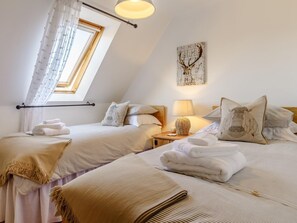 A bedroom with two beds, a skylight, a lamp, and a wall art piece. - 2 Bed in Newton Abbot (oc-81436) (Dainton)