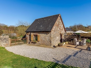A stone building with a sloped roof, a gravel driveway, and a wooden fence. - 2 Bed in Newton Abbot (oc-81436) (Dainton)