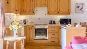 Eine Küche mit Holzausstattung, einer Mikrowelle, einem Toaster und einem Spülbecken.