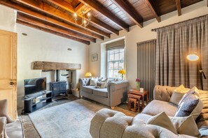 A cozy living room with a fireplace, sofa, and television. - 5 Bed in Richmond (oc-81457) (Gunnerside)