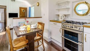 Una cocina con estufa, horno y muebles blancos.