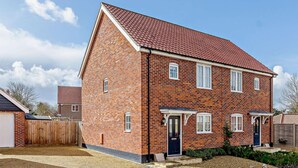 A two-story brick house with a red-tiled roof, a front porch, and a small garden area. - 3 Bed in Cromer (oc-81481) (Overstrand)