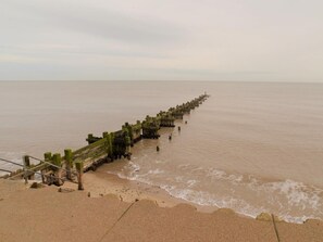 A long pier extending into a calm body of water, with a sandy beach on one side. - 3 Bed in Cromer (oc-81481) (Overstrand)