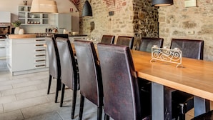 A dining area with brick ceiling, wooden table, and leather chairs. - Casa Carlin, Cascine Crema: large house that sleeps up to 11 people, with a 20x14 m pool (Piemonte)