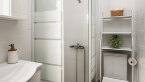 A modern bathroom with a glass-enclosed shower, a toilet, and a sink. - Stavros Two-Bedroom House by Konnect (Corfu)