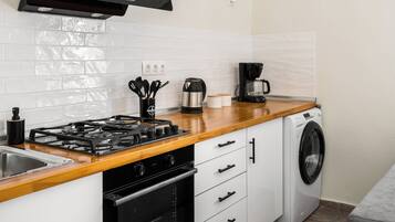 A modern kitchen with a gas stove, oven, microwave, and a built-in washing machine.