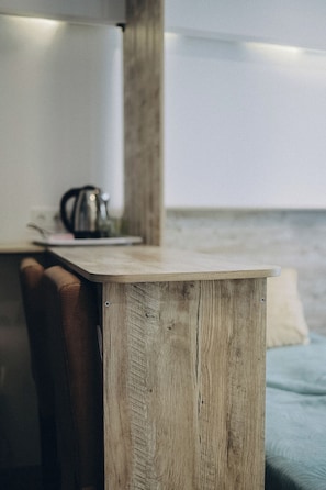 Un tavolo di legno con un bollitore metallico sopra, vicino a una finestra che si affaccia sull'acqua.
