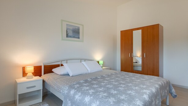 A bedroom with a bed, nightstands, a wardrobe, and a framed picture on the wall. - Casa Aneri by Villas Guide (Pavicini)