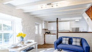 Un intérieur moderne avec un coin repas, un canapé bleu et une cuisine en arrière-plan.