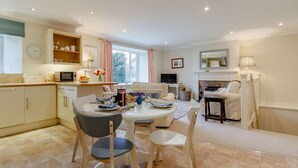 Una cocina moderna con comedor, chimenea y televisor.