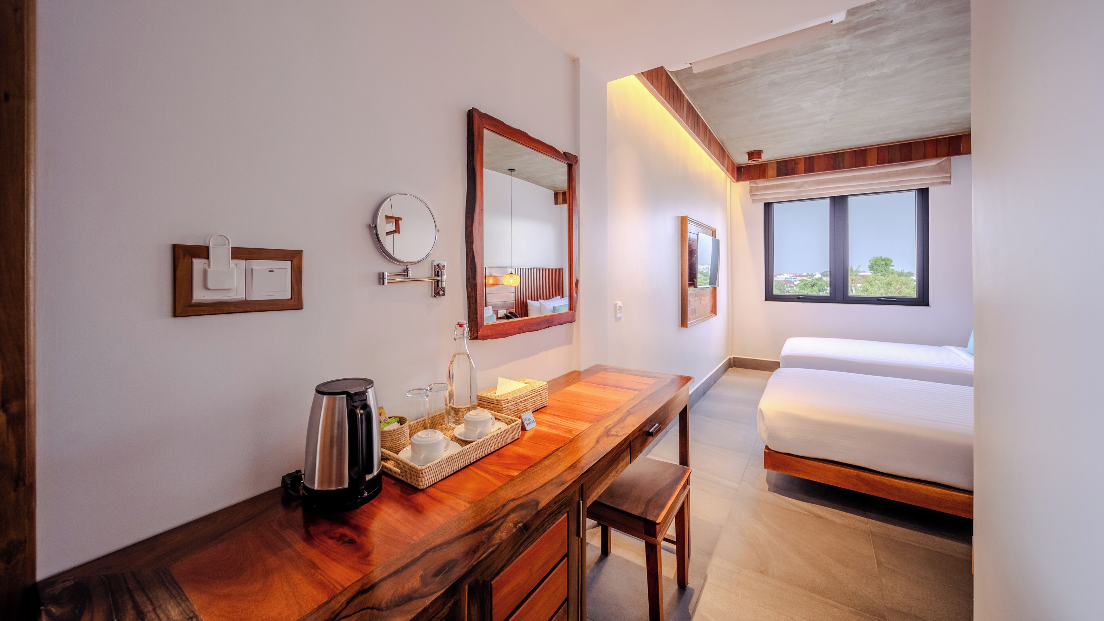 Ein Hotelzimmer mit einem Holztisch, einem Bett, einem großen Spiegel und einem Fenster mit Blick.