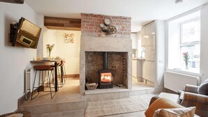 A living room with a fireplace, a dining area, and a kitchen. - 2 Bed in Morpeth (oc-82238) (Rothbury)