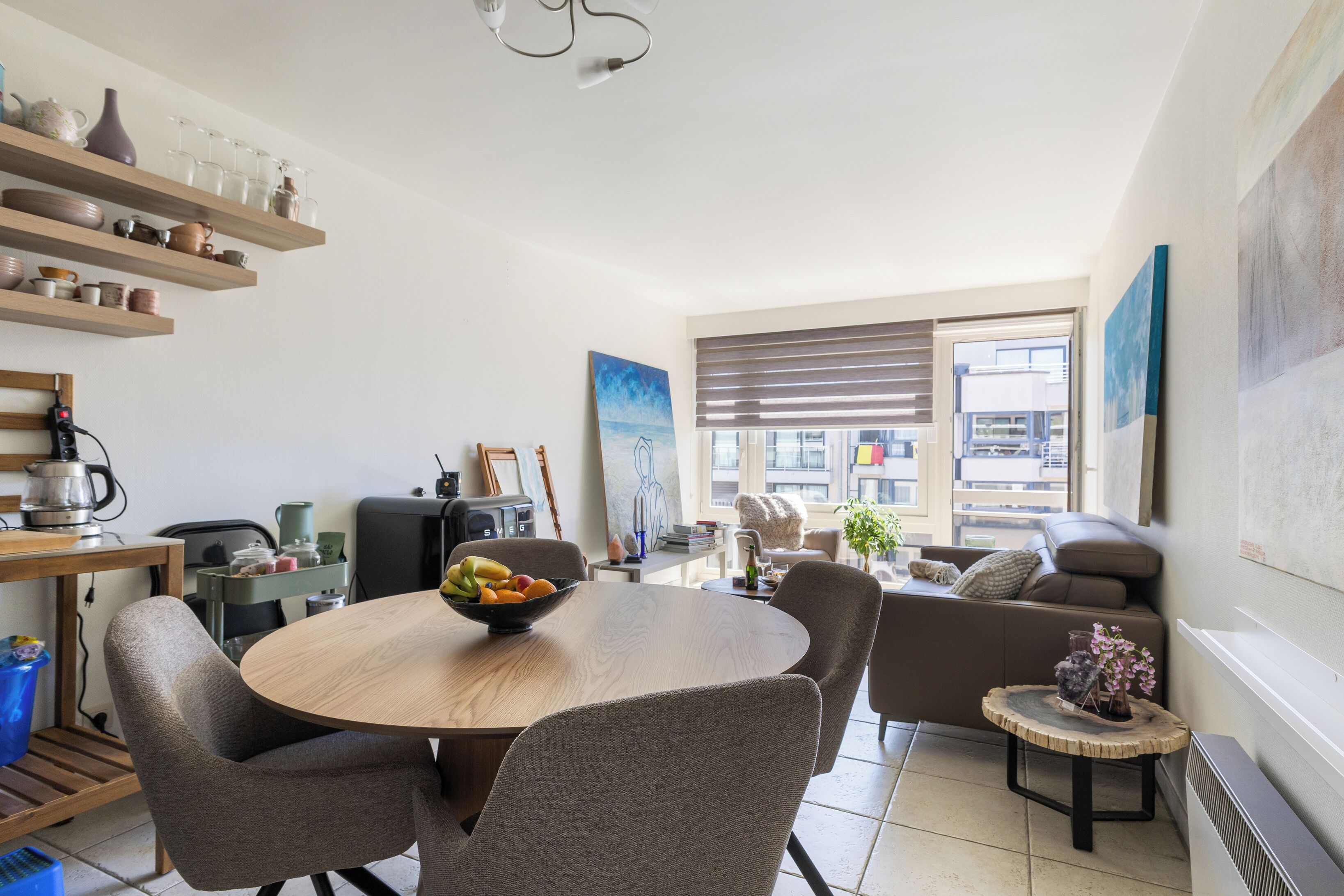 Eine moderne Küche mit Essbereich, einer Couch und Blick auf die Stadt.