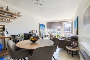 Een moderne keuken met een eetgedeelte, een bank en uitzicht over de stad.