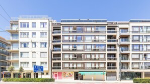 A multi-story building with balconies, a storefront, and a sign indicating directions to De Panne and Koksijde. - 1 bedroom accommodation in Oostduinkerke (Oostduinkerke)