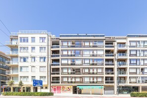 A multi-story building with balconies, a storefront, and a sign indicating directions to De Panne and Koksijde. - 1 bedroom accommodation in Oostduinkerke (Oostduinkerke)
