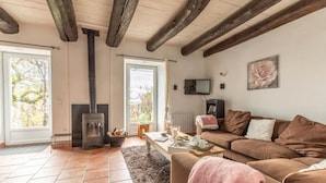 Ein gemütliches Wohnzimmer mit Kamin, einer Couch, einem Couchtisch und einem Fernseher.