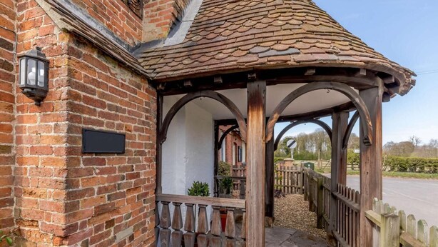 A brick building with a covered porch, a black mailbox, and a wooden fence. - 2 Bed in Ashbourne (oc-82579) (Longford)