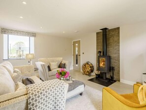 A modern living room with a fireplace, sofas, and a yellow armchair. - 2 Bed in Skipton (oc-82602) (Buckden)