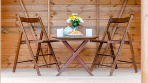 Een houten interieur met twee stoelen, een tafel en een vaas met bloemen.
