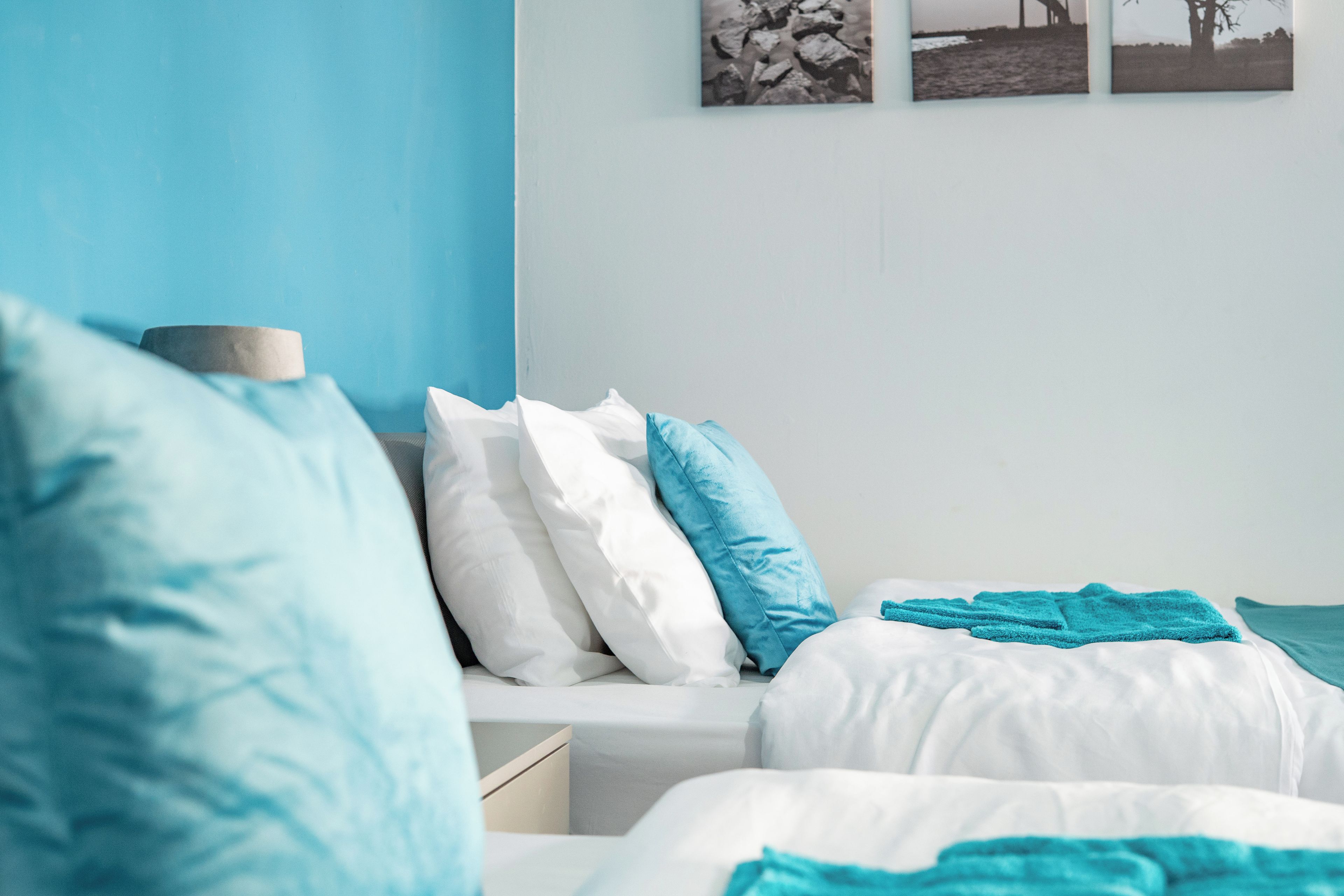 A bedroom with a bed, pillows, and a bedside table.