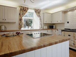 A kitchen with white cabinets, a wooden countertop, a microwave, and a kettle. - 3 Bed in Biggar (oc-82924) (Biggar)